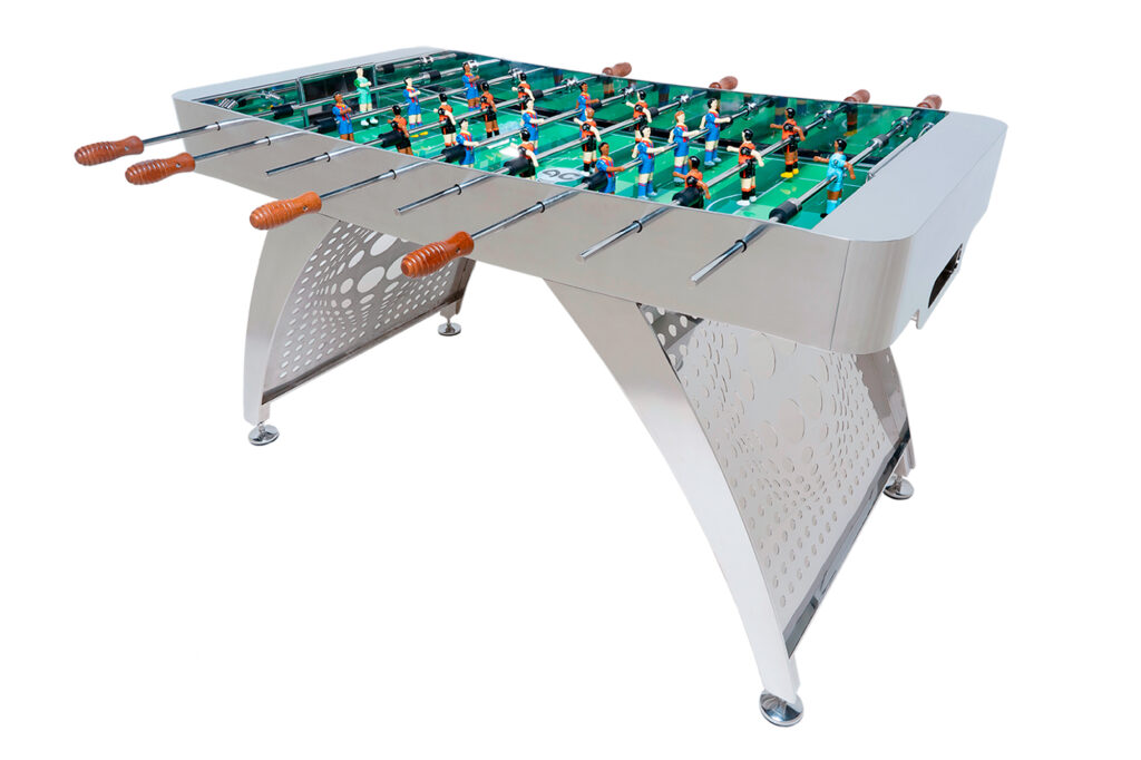Modelo premium fabricado en acero inoxidable AISI 316 con acabado pulido brillante. Patas efecto tubo, pista en tonos verdes y jugadores con equipaciones clásicas del Real Madrid y F. C. Barcelona. Mangos de iroko natural. Disponible con o sin monedero
